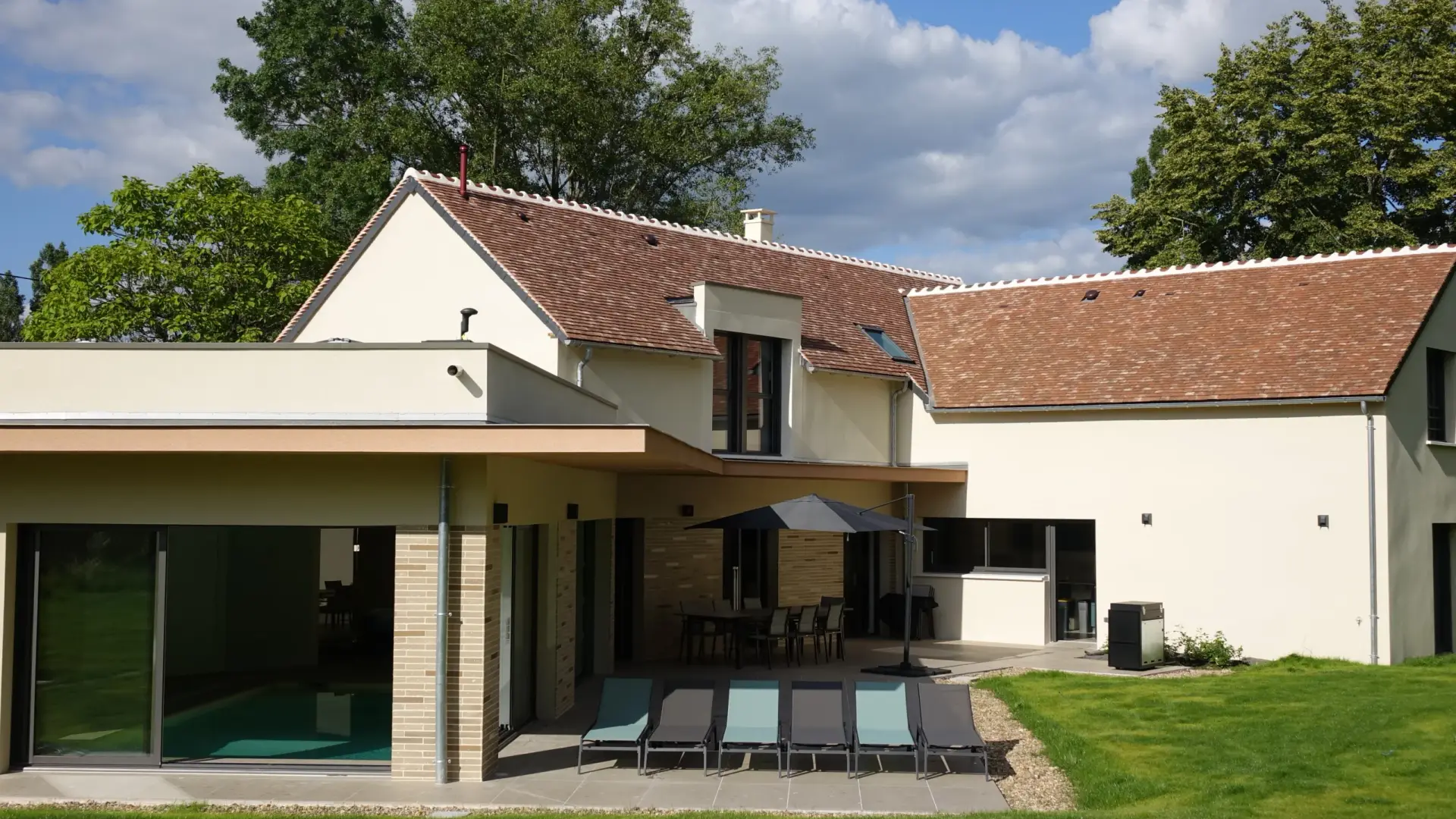 La façade de la villa et la terrasse aux transats