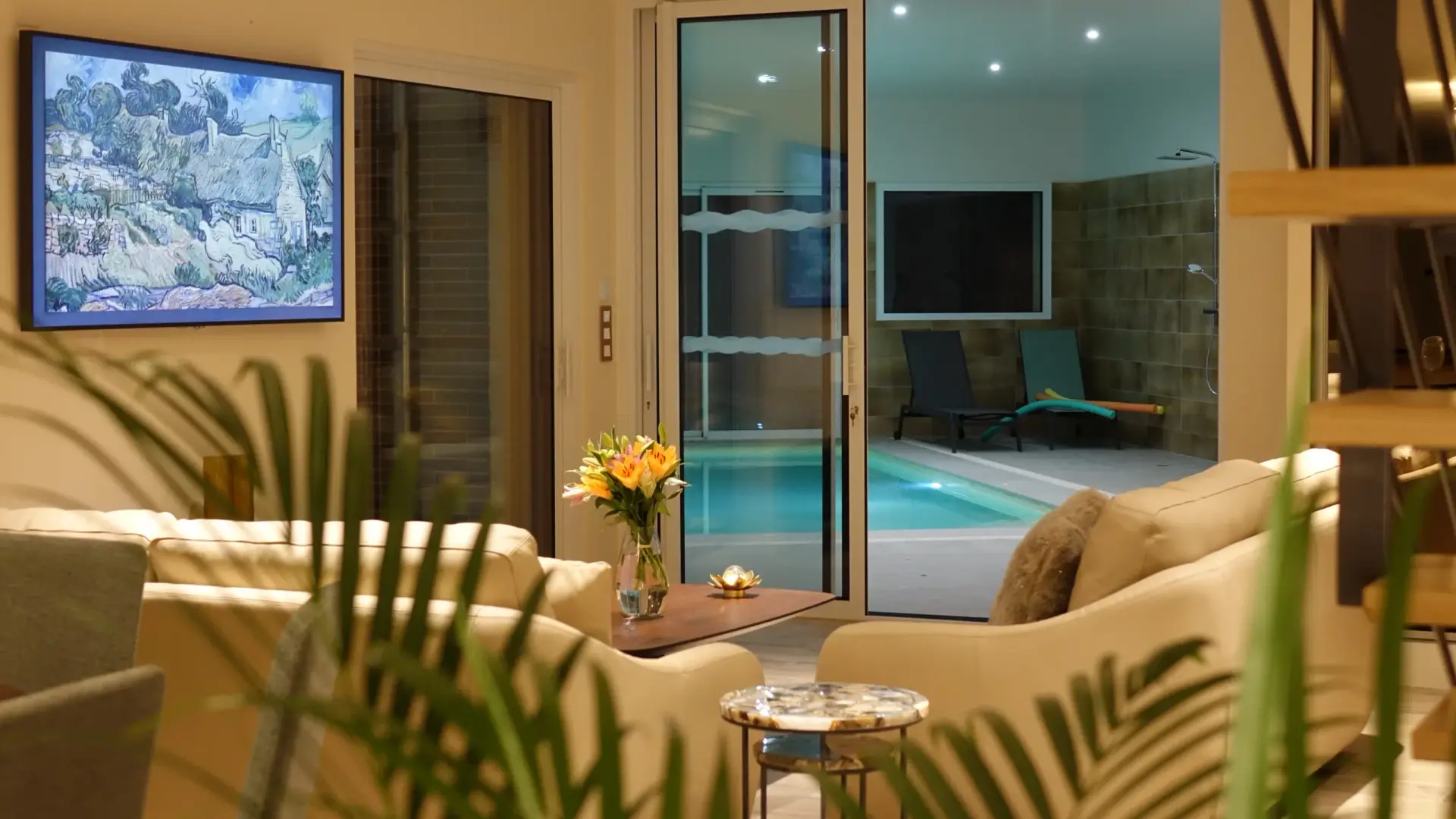 Le salon le soir, avec vue sur la piscine intérieure