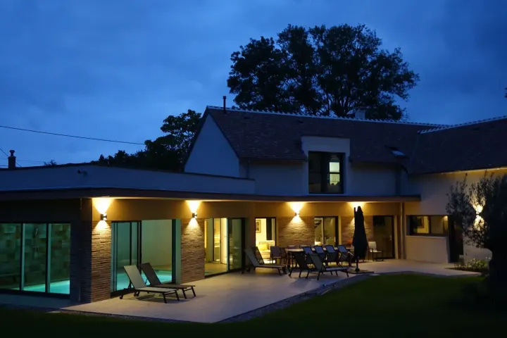 La villa illuminée à la tombée de la nuit